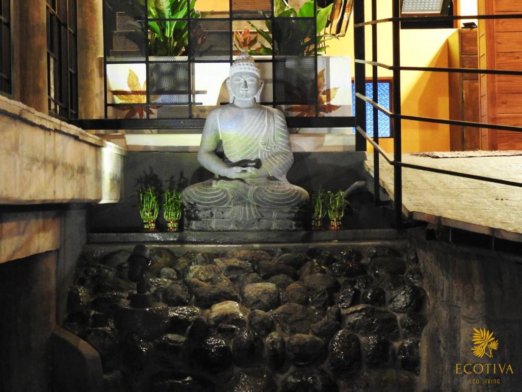 uma grande estátua sentada numa piscina de água em Villa Ecotiva em Pondicherry