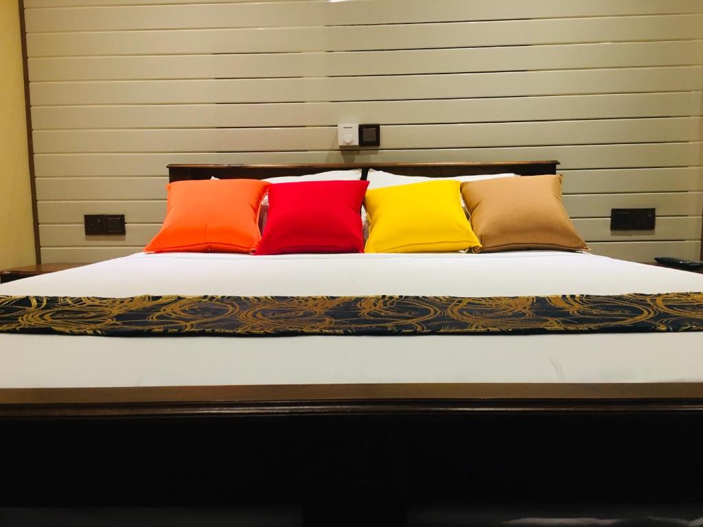 a bed with four different colored pillows on it at Villa Forest View - No: 50/17 in Kandy