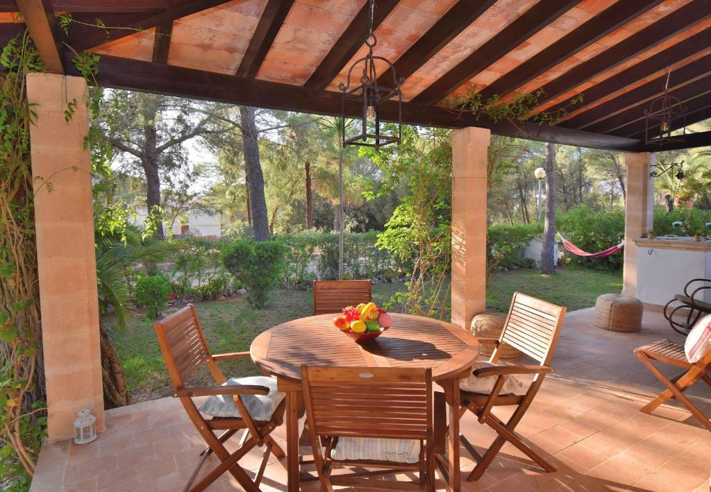 een houten tafel en stoelen op een patio bij Casa Trevol 020 by Mallorca Charme in Alcudia