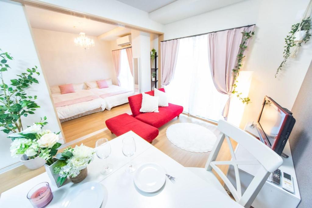 a living room with a red couch and a red chair at Miraie Osaka Higashinari202 in Osaka