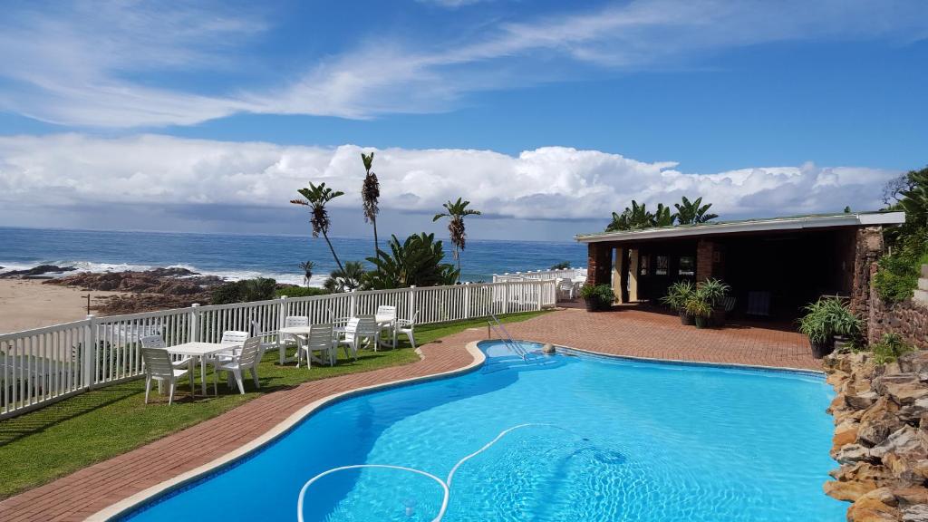 a swimming pool with a view of the ocean at Villa del Sol Margate in Margate