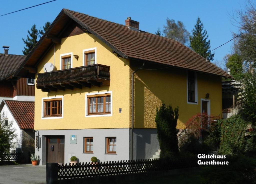 a yellow and white house with a balcony at Gästehaus am Weinberg - Schlager in Prinzersdorf