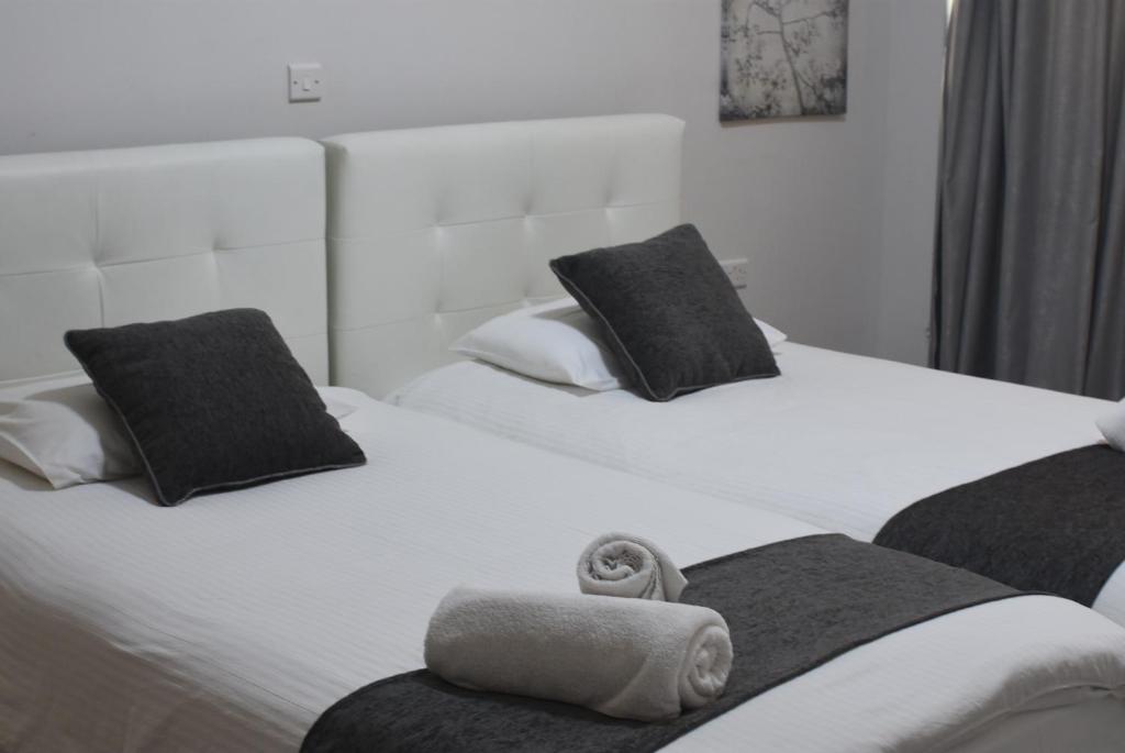 2 Betten mit schwarzen und weißen Handtüchern darauf in der Unterkunft Rimon Cyprus Israeli Kosher Rooms in Larnaka
