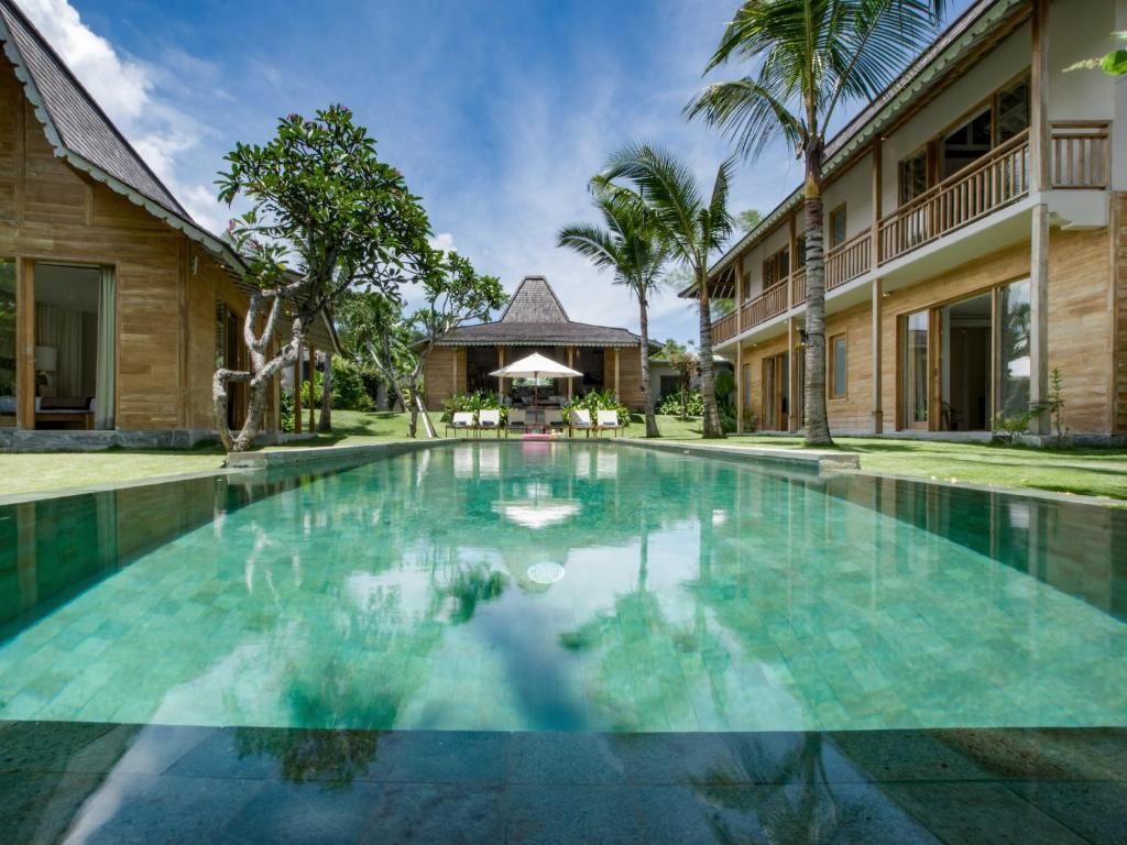 a swimming pool in front of a house at Villa Alea in Kerobokan