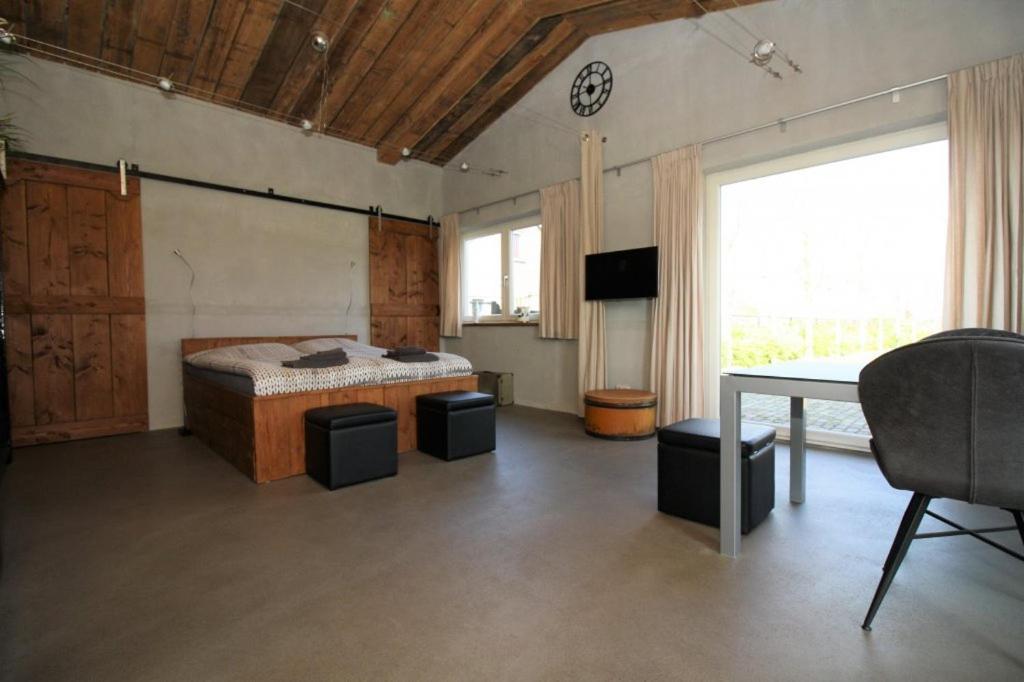 een slaapkamer met een bed, een tafel en een raam bij Studio Rent Jamzes in Hoogerheide