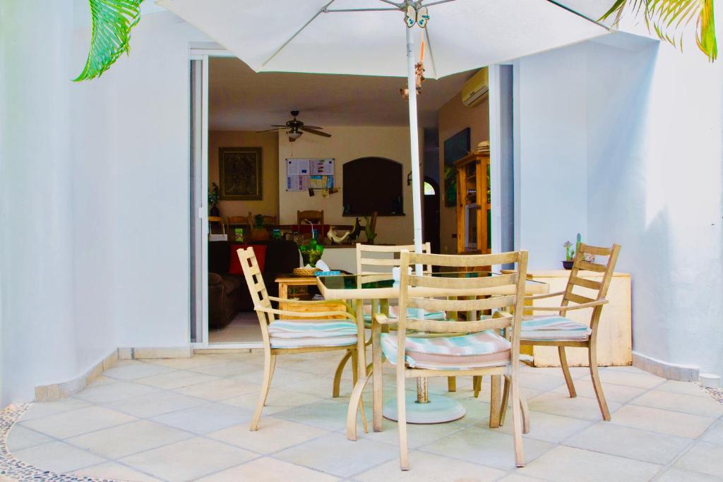 una mesa y sillas con una sombrilla blanca en Superior Room E8 Dolce Vita Caribe B&B, en Playa del Carmen