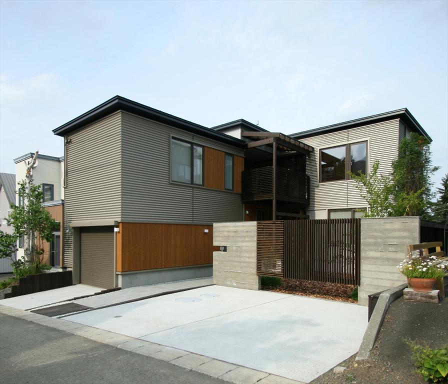 een modern huis met een zwarte en houten gevel bij Shimogoryo House in Furano