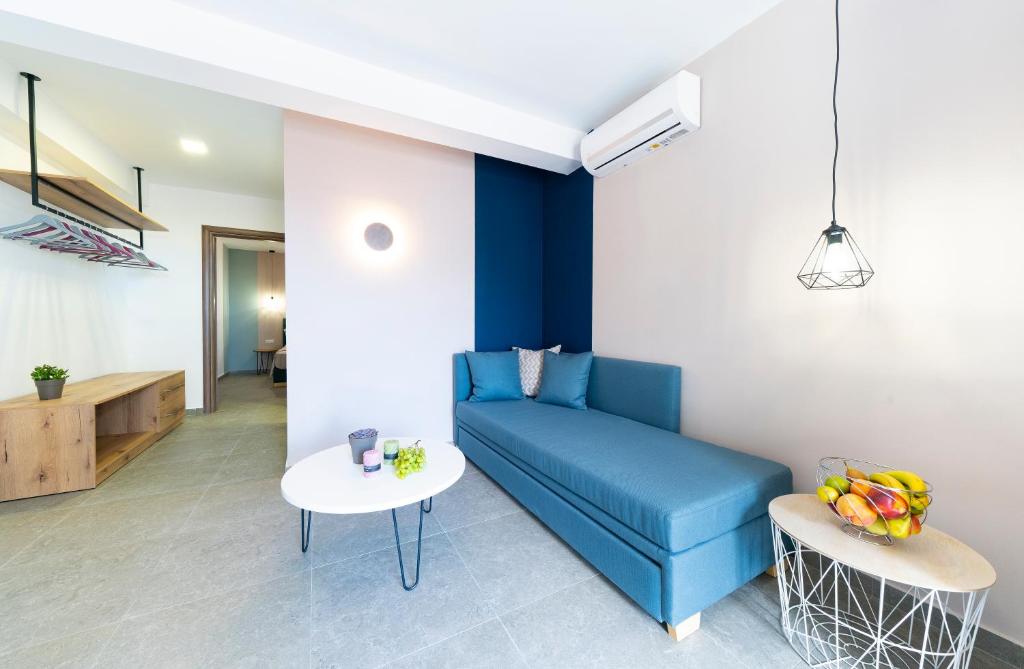 a living room with a blue couch and a table at Villa Elia in Kavala