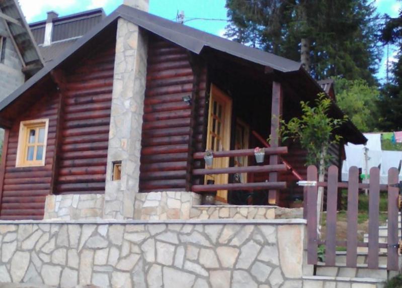 une cabane en rondins avec une clôture devant elle dans l'établissement Cozy Cabin, à Žabljak