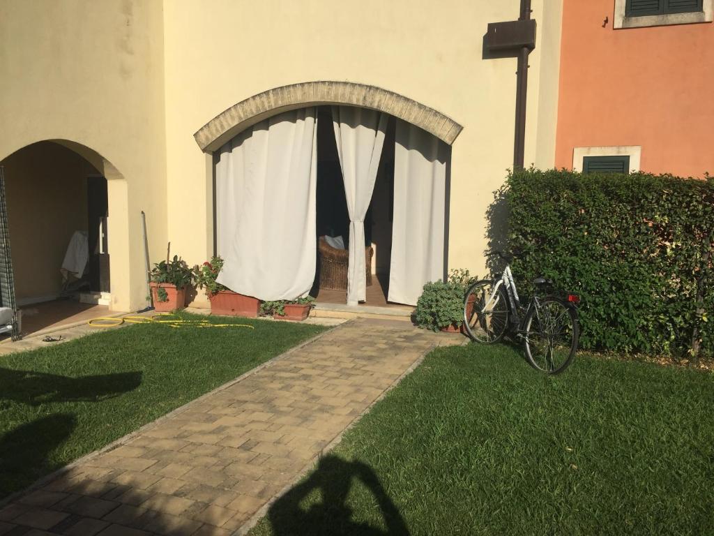 a bike parked in the grass next to a house at Villetta indipendente presso Villaggio Demetra Policoro in Policoro