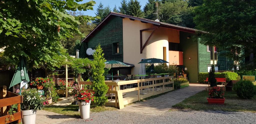 una casa con una valla y flores delante de ella en Le Pavillon, en Cours la Ville