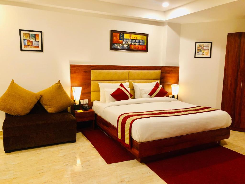 een hotelkamer met een bed en een stoel bij Red Crown Hotel in New Delhi