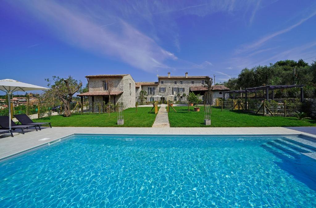 a large swimming pool in front of a house at Dogoli Country Apartments in Bardolino