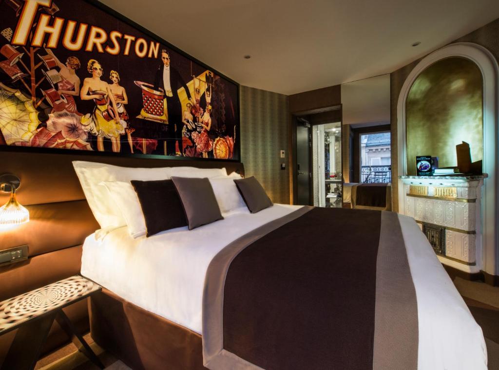 um quarto com uma cama grande e um cartaz na parede em Hotel Splendor Elysées em Paris