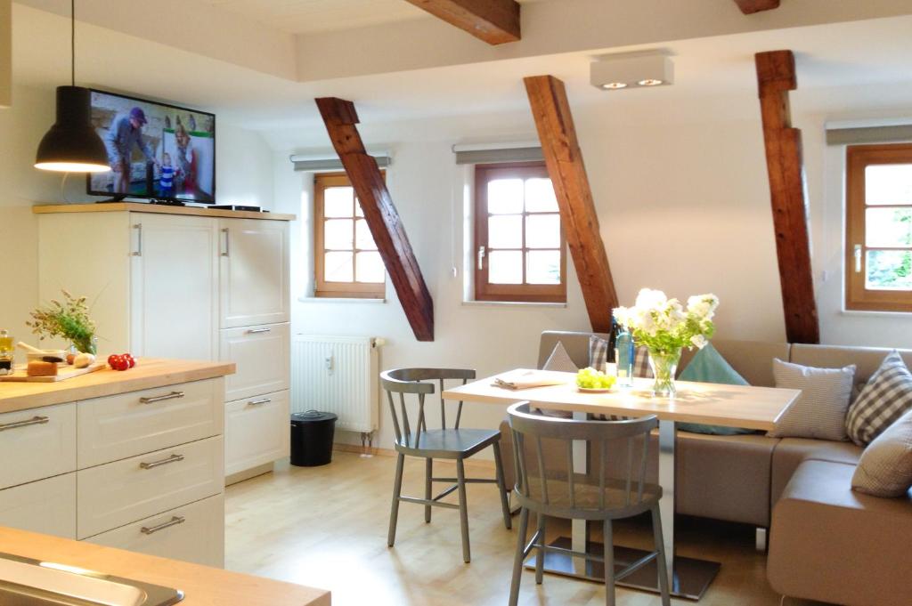 een keuken en een woonkamer met een tafel en een bank bij Altendorfer Vorwerk in Altendorf