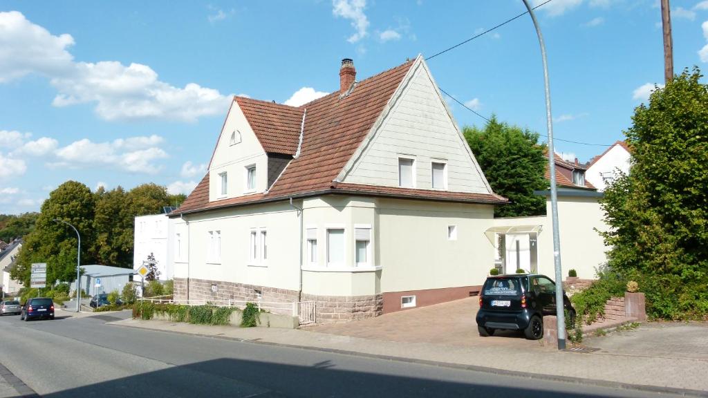 une maison blanche avec un toit marron dans une rue dans l'établissement Casa Maria App. Jose 1. Obergeschoss, à Saint-Wendel