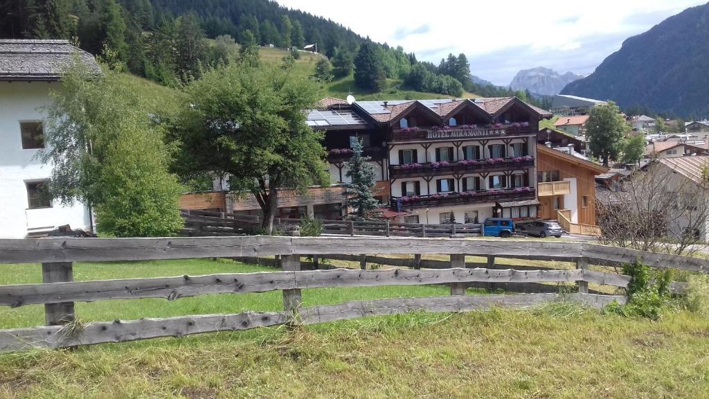 une clôture en bois devant un village dans l'établissement Hotel Miramonti, à Vigo di Fassa