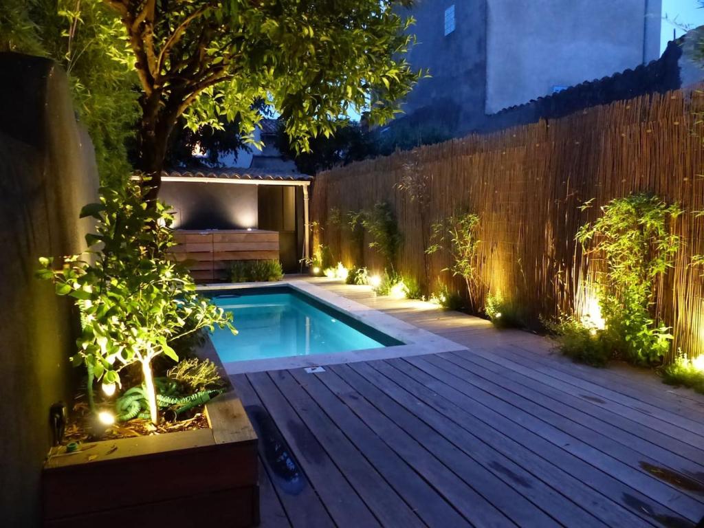 una piscina en un patio trasero por la noche con luces en La Civadière en Cogolin