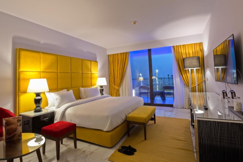 a hotel room with a large bed and a balcony at Porto Said Resort & Spa in Port Said