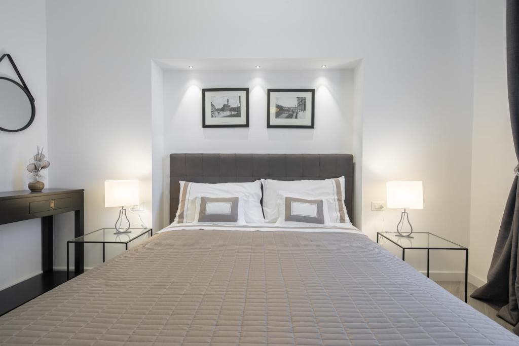 una camera con un grande letto con tre immagini appese al muro di Palace Downtown Florence a Firenze