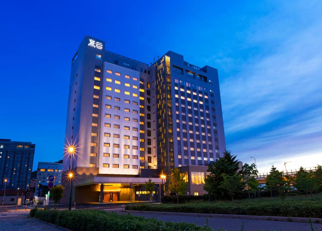 a tall building with lights on in a city at HOTEL＆SPA CENTURY MARINA HAKODATE in Hakodate