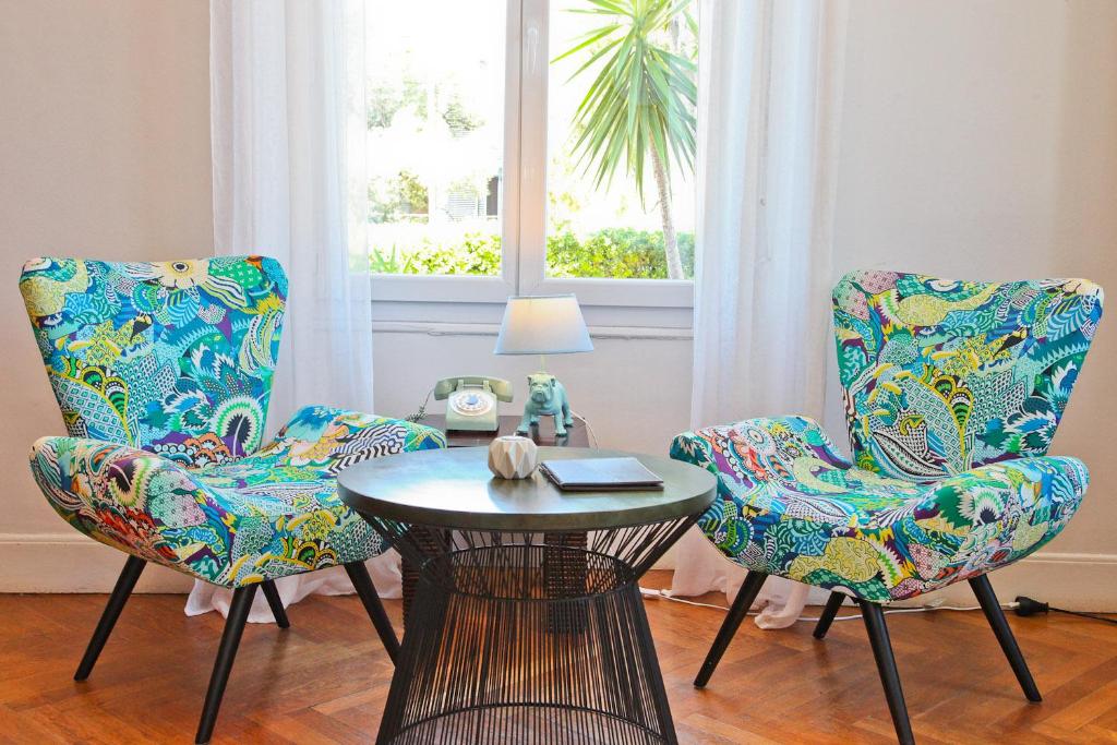 a room with two chairs and a table and a window at Hôtel La Villa Cap d’Antibes in Juan-les-Pins