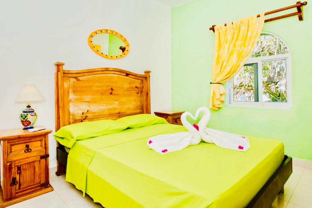 a bedroom with a bed with a bow on it at Deluxe Family Budget Balcony Room with Pool Playacar Ii in Playa del Carmen