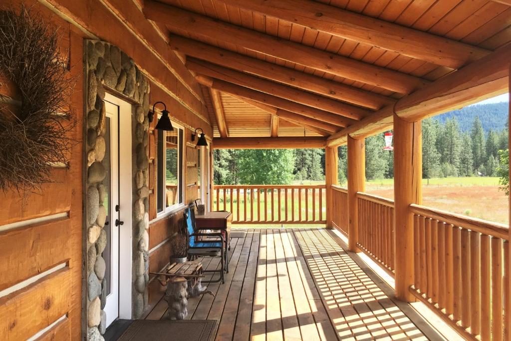 a porch of a wooden cabin with chairs and a dog at Forestside Lodge in Leavenworth