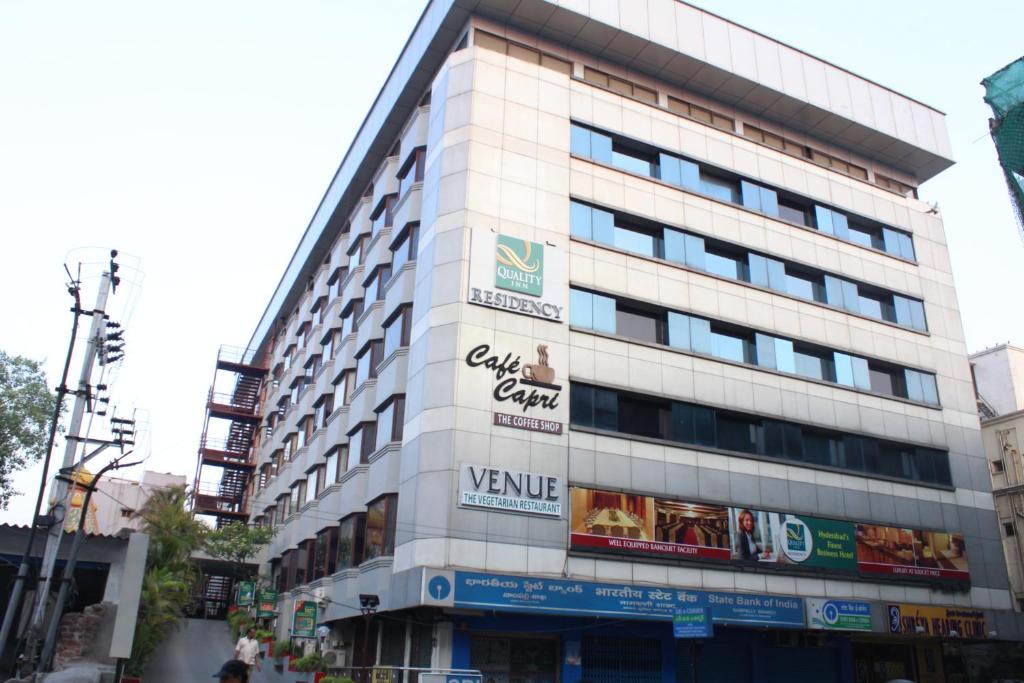 Quality Inn Residency في حيدر أباد: مبنى أبيض طويل مع العديد من الإشارات عليه