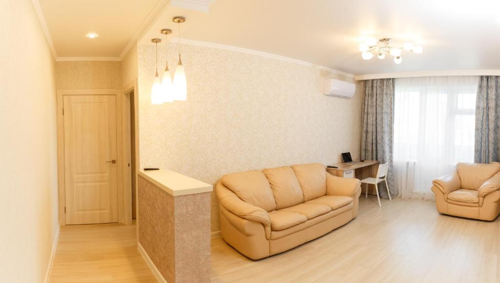 a living room with two chairs and a table at Роскошные апартаменты RentHome в центре in Kemerovo