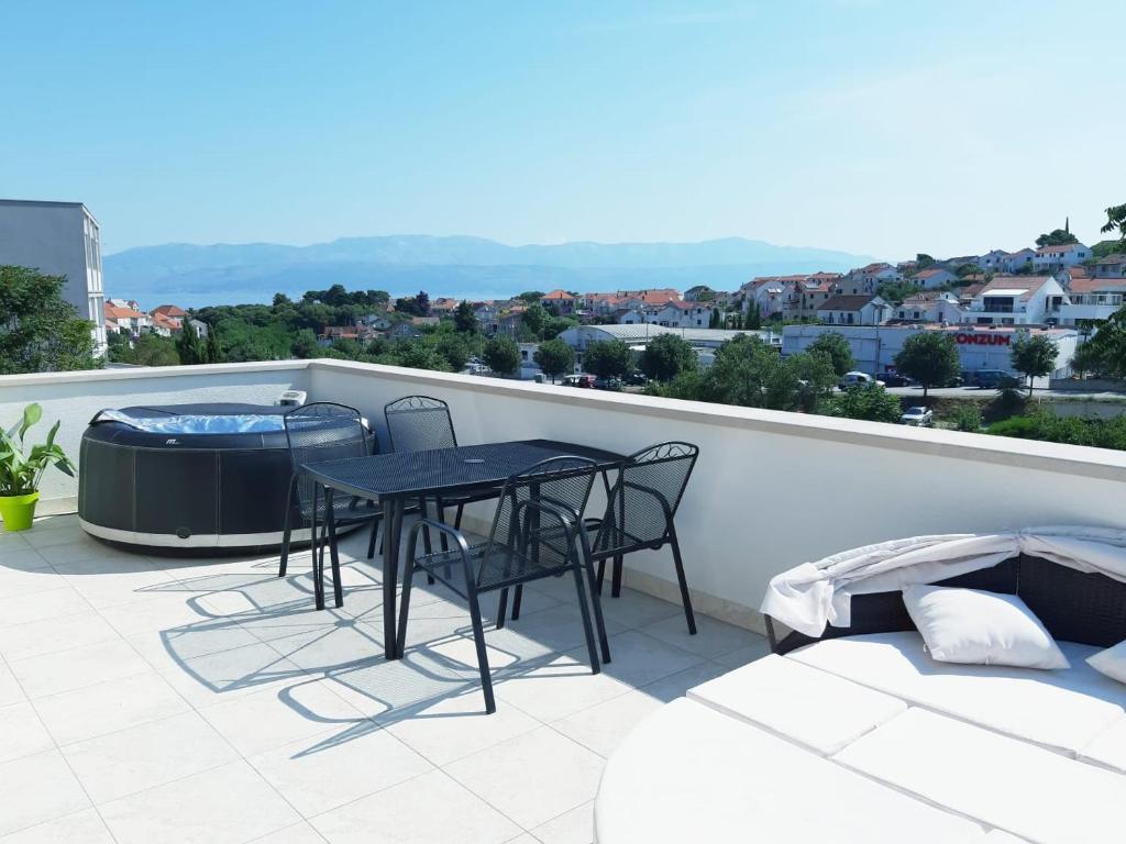 a balcony with a table and chairs and a hot tub at apartman Marina in Sutivan