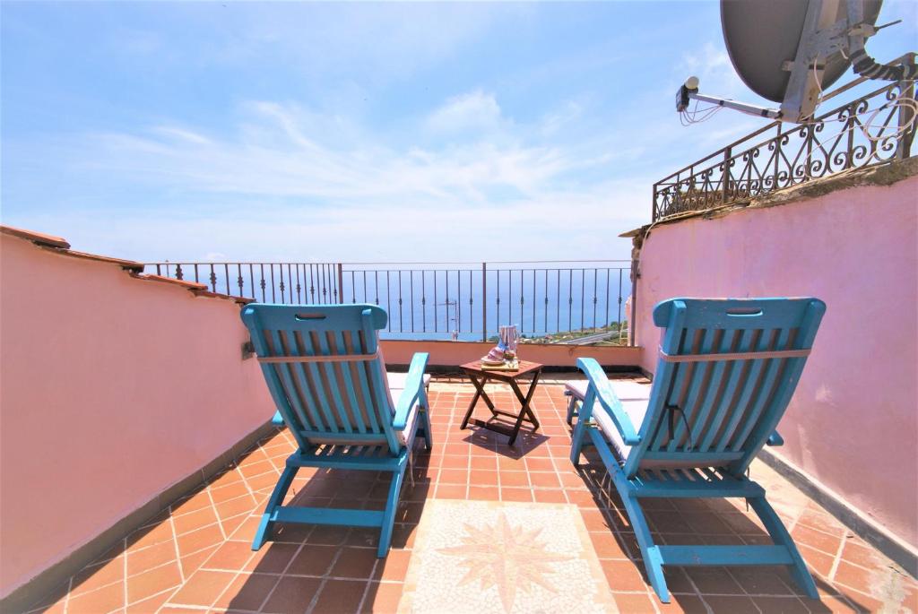 twee blauwe stoelen op een balkon met een tafel bij da Patrick in Costarainera