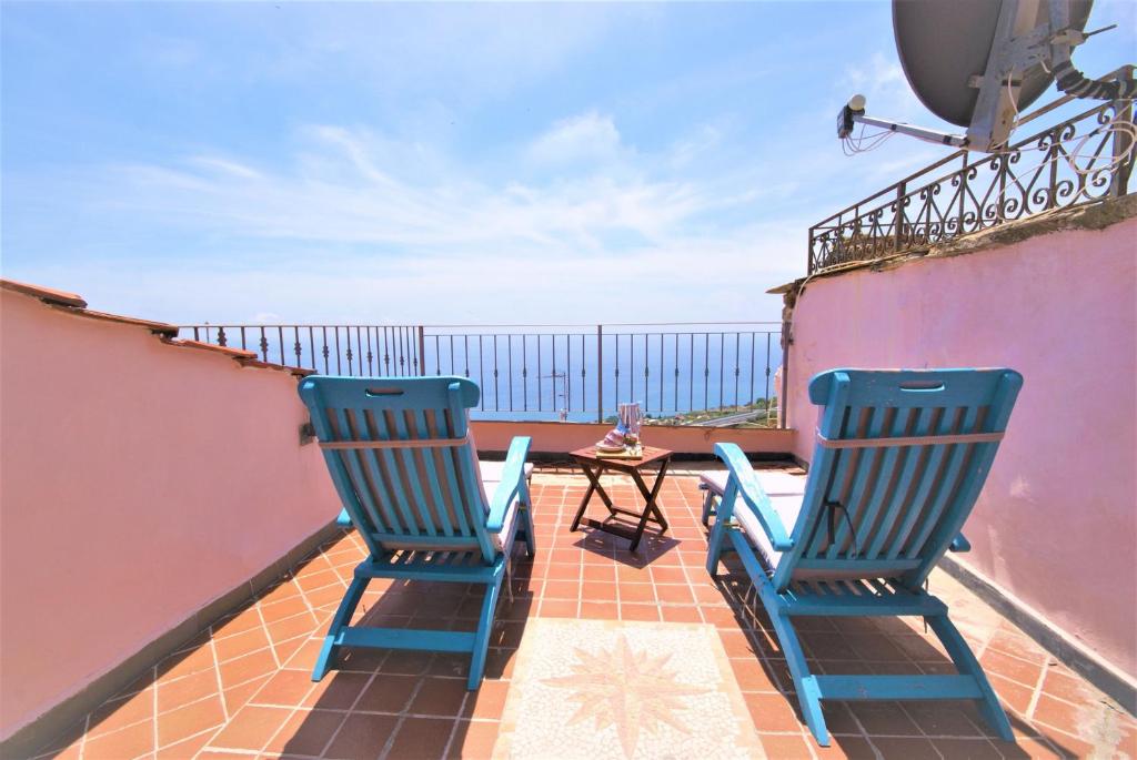 two blue chairs sitting on a balcony with a table at da Patrick in Costarainera