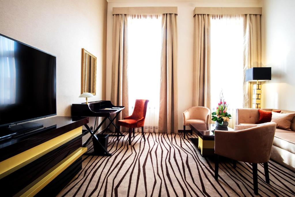 a living room with a flat screen tv and a couch at Boutique Hotel Slávia in Košice