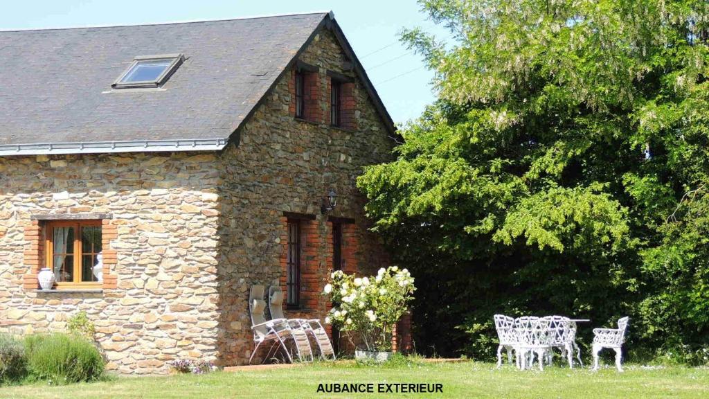 Casa de piedra con 2 sillas y mesa en Gîte Aubance 5 Places Moulin de la Placette en Faye-dʼAnjou
