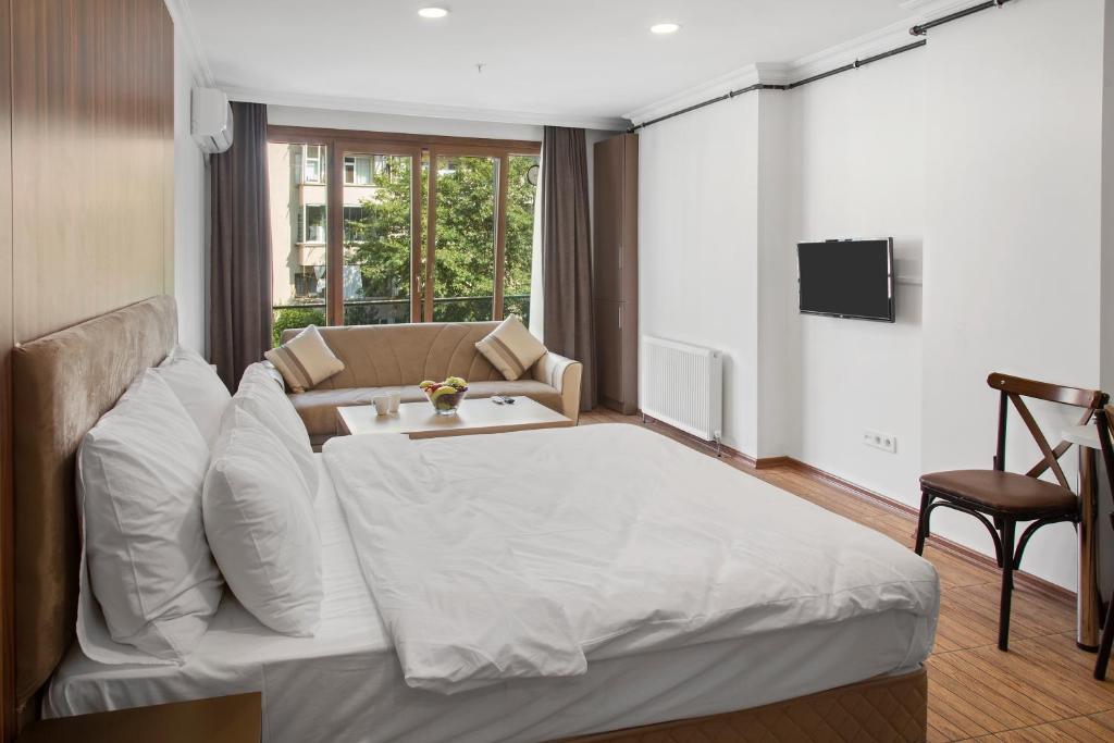 - une chambre avec un grand lit blanc et un canapé dans l'établissement Modern Suites, à Istanbul