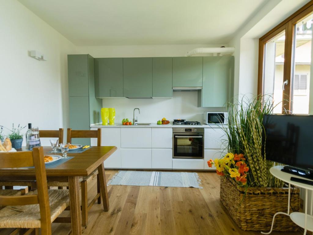 kuchnia z zielonymi szafkami i drewnianym stołem w obiekcie Discesa a Lago with terrace and garden on lake Iseo w mieście Riva di Solto
