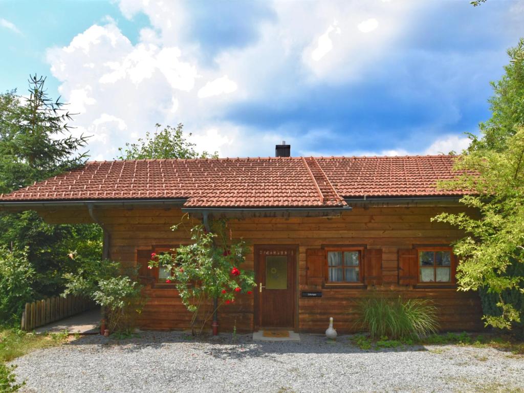 ein Holzhaus mit rotem Dach in der Unterkunft Vintage Holiday Home in Grafenried with Garden in Drachselsried