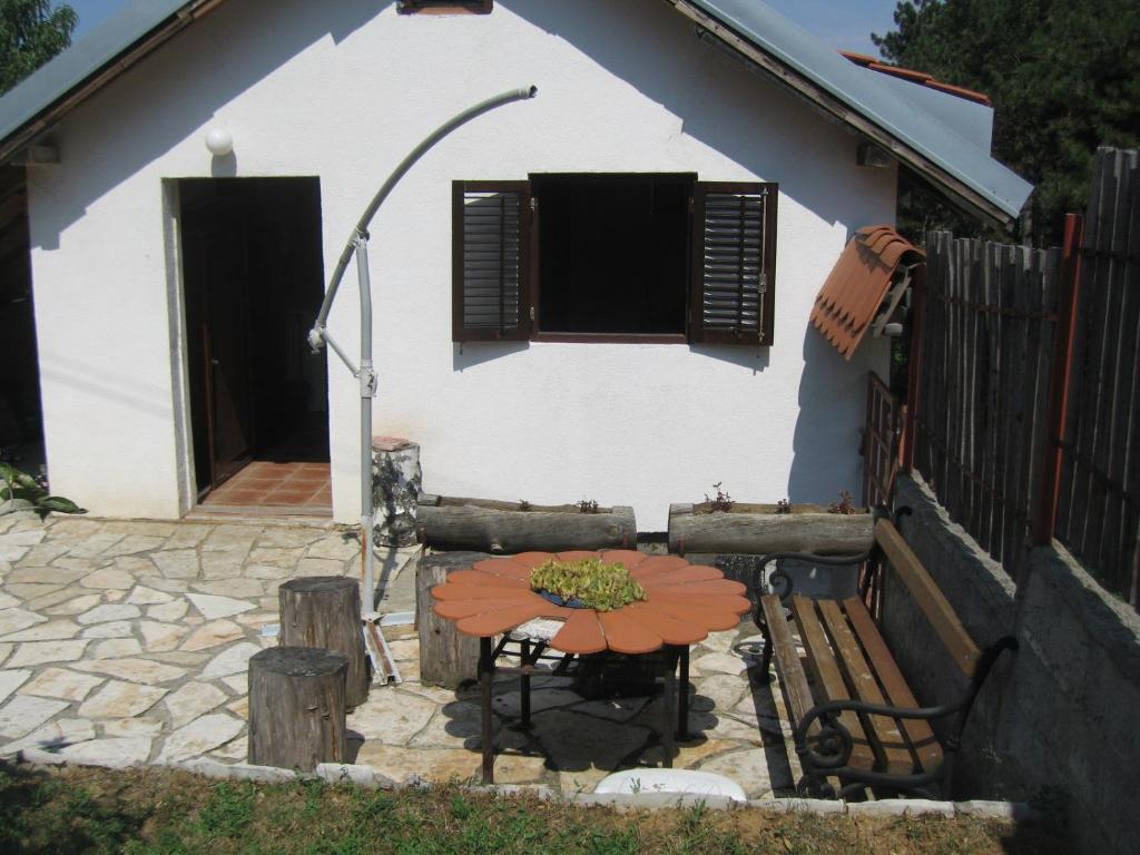 una mesa y un banco frente a una casa en Cosy Cottage on Avala Mountain en Belgrado