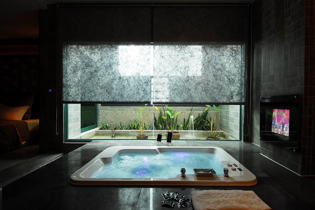 uma banheira na casa de banho com uma janela em All-Ur Boutique Motel -Chia Yi Branch em Chiayi