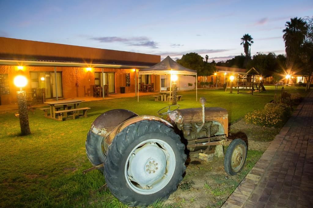 un viejo tractor estacionado frente a un edificio en Culdesac Guesthouse Oudtshoorn, en Oudtshoorn