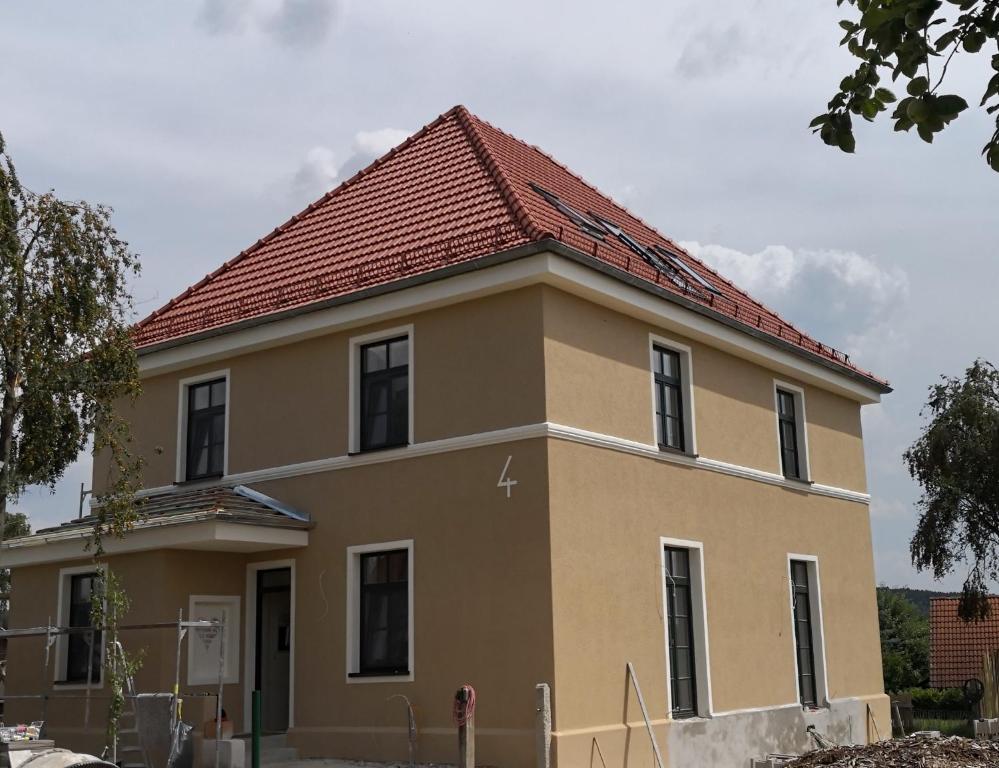 una gran casa amarilla con techo rojo en Casa Benefizium en Langquaid