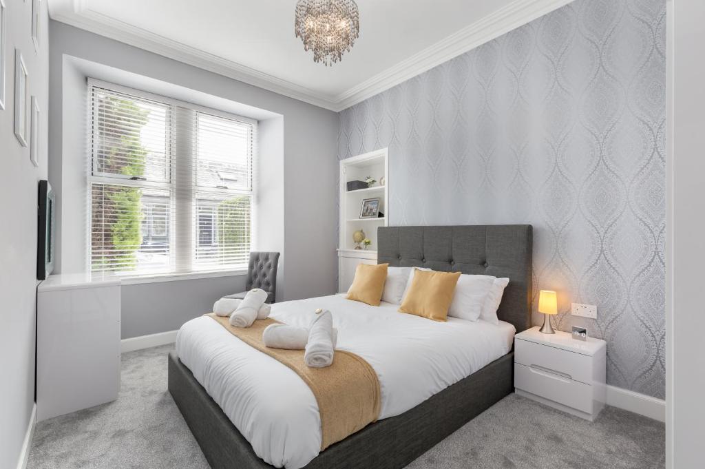 a bedroom with a large bed with white and orange pillows at No 46 - by StayDunfermline in Dunfermline