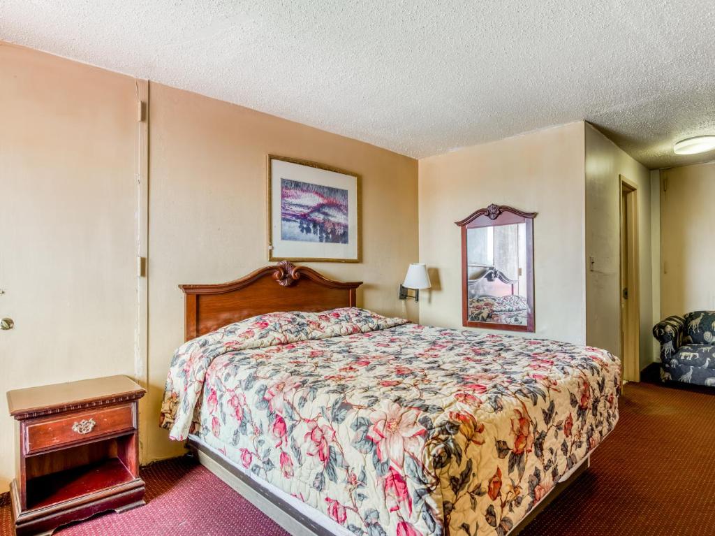 a bedroom with a large bed and a table at OYO Hotel Jackson North I-55 in Jackson
