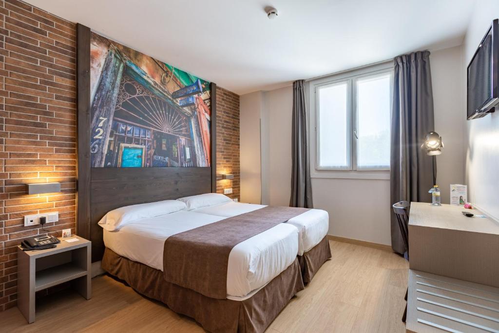 a hotel room with a bed and a brick wall at Casual del Jazz San Sebastián in San Sebastián