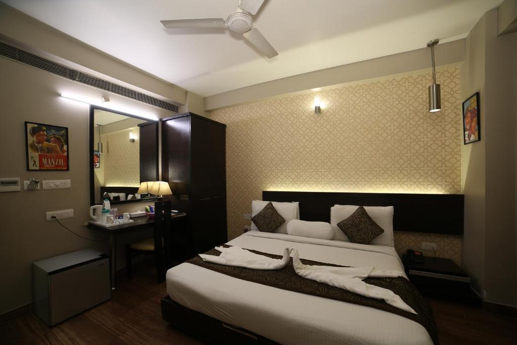 新德里的住宿－WoodApple Residency，一间卧室配有一张床、一张书桌和一面镜子