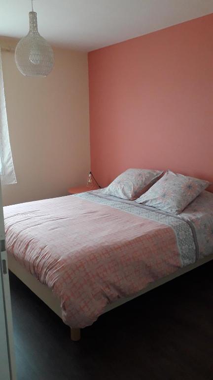 1 dormitorio con 1 cama con pared de color rosa en La halte chambre chez l habitant, en Bonnes