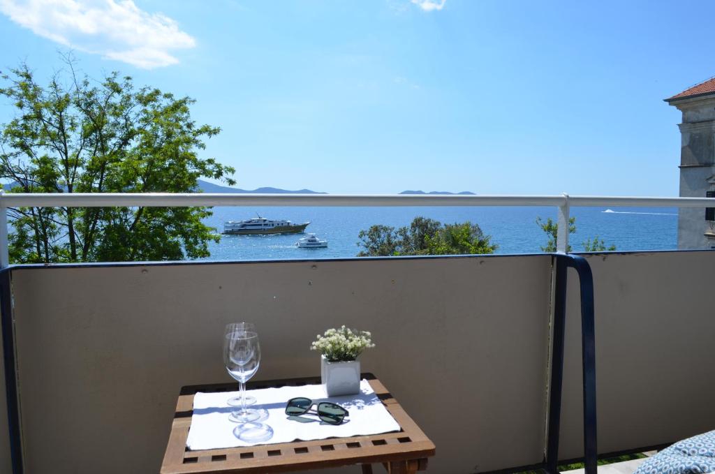 una mesa en un balcón con vistas al agua en Apartment Roxy, en Zadar