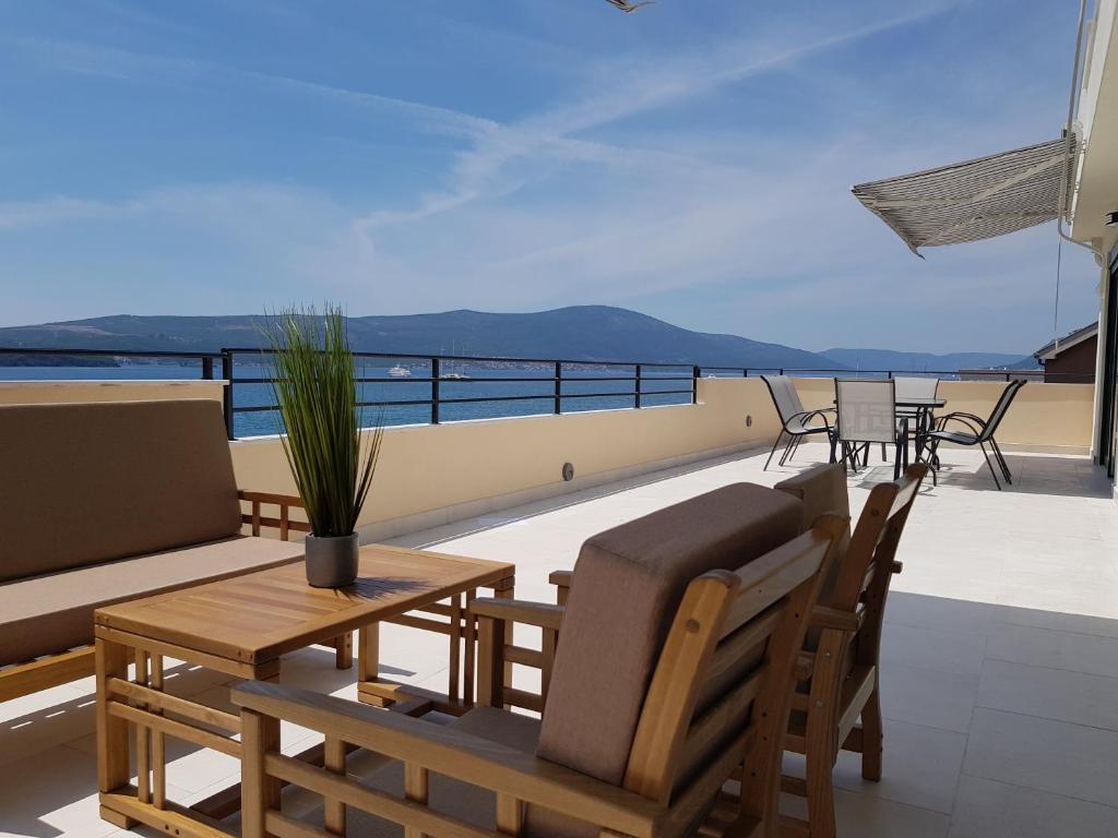 a balcony with a table and chairs and a view of the ocean at Obala in Tivat