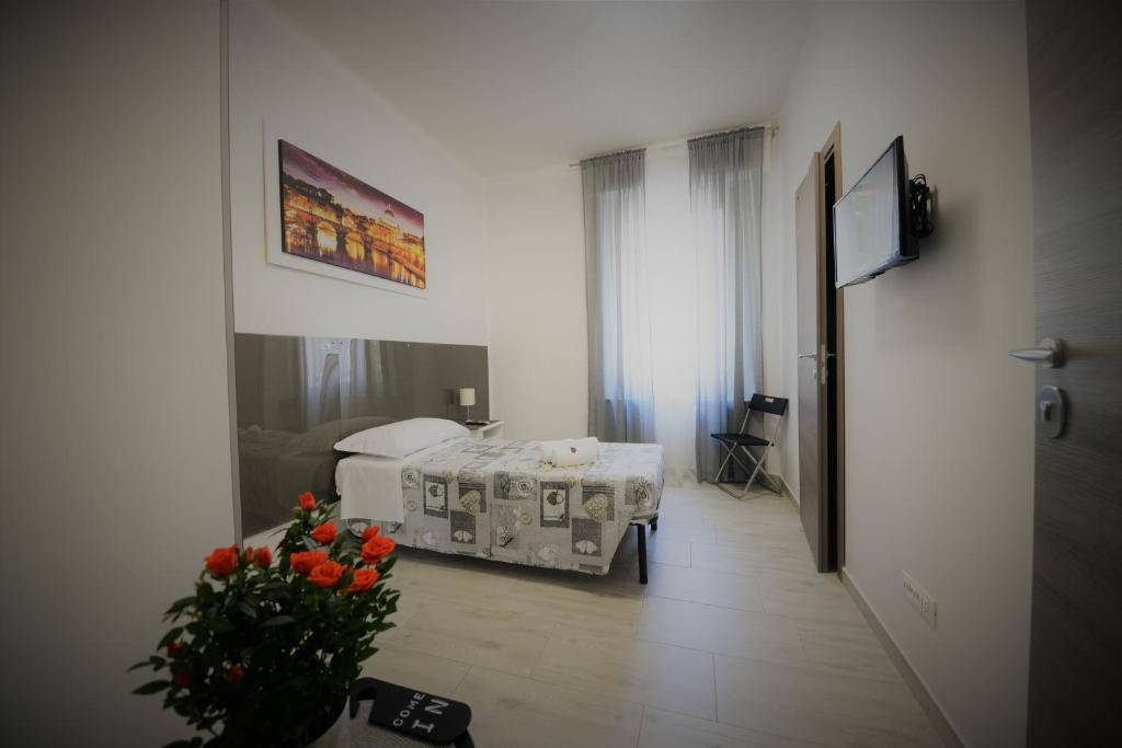 um quarto de hospital com uma cama e um vaso de flores em AFFITTACAMERE A CASA MIA em Roma
